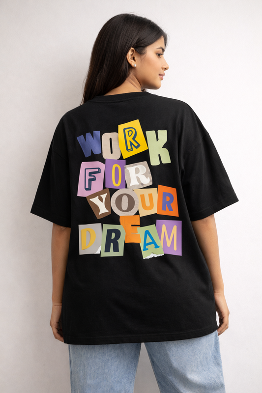 Person wearing a black t-shirt with colorful text on the back against a plain background