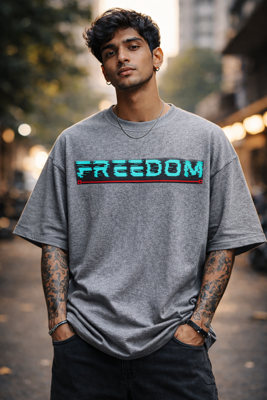 Man wearing a gray t-shirt with 'FREEDOM' printed on it, standing outdoors.